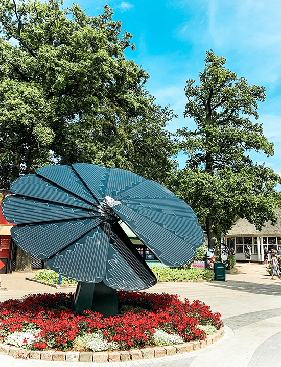 Decorative SmartFlower solar array featured in garden plaza near pedestrian shopping area