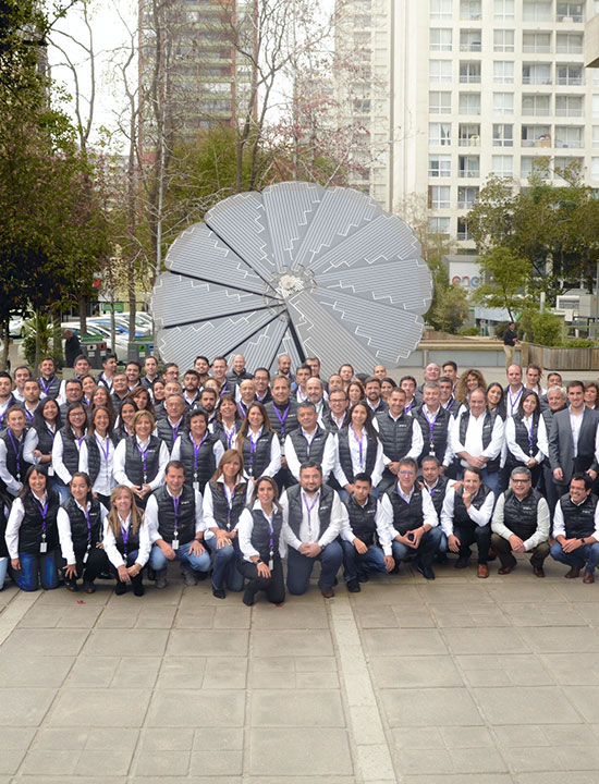 Professional team portrait with SmartFlower solar array in urban office building background